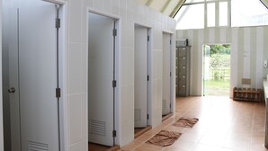 A hallway with white doors, a tiled floor, and a view of the outdoors. - Rai Ruen Rom Organic Farm (Thoeng)