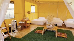 A tented accommodation with multiple beds, a fan, a table with a basket, and a window. - Rai Ruen Rom Organic Farm (Thoeng)