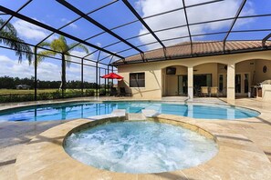 A swimming pool with a hot tub, surrounded by a covered patio area with chairs and umbrellas. - Je48322 - Reunion Resort - 6 Bed 6 Baths Villa (Kissimmee)