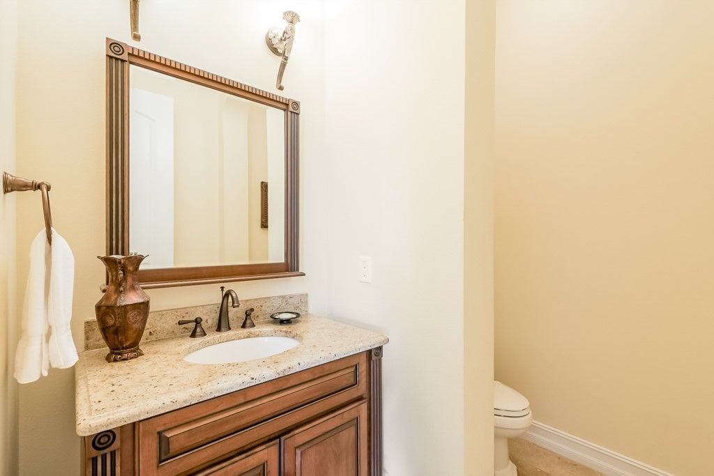 Une salle de bain avec un meuble-lavabo en bois, un évier, un miroir et des toilettes.