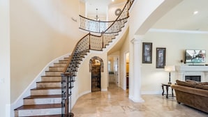 A spacious living area with a curved staircase, a fireplace, and a comfortable seating area. - Je50286 - Reunion Resort - 5 Bed 5 Baths Villa (Kissimmee)