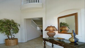 A hallway with a staircase, a lamp, a mirror, and a plant. - Je37919 - Reunion Resort - 4 Bed 4 Baths Villa (Kissimmee)
