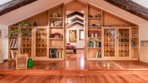 A spacious attic room with wooden bookshelves, a wooden floor, and a sloped ceiling. - VIVALDI APARTMENT ON TWO LEVELS WITH ATTIC (Venezia)