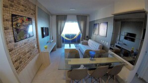 A modern living space with a dining area, kitchen, and seating area. - Apartamento Luxo vista mar, muito aconchegante VP803 (Fortaleza)