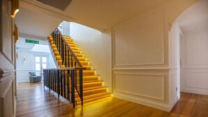 Eine Treppe mit gelben Stufen und schwarzen Geländern, die zu einer Tür führt, auf der "KELUAR" steht.