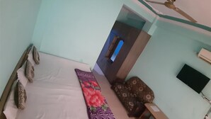 Quarto com cama, escrivaninha, cadeira, guarda-roupa e televisão.
