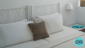 Een netjes ingerichte hotelkamer met een bed, een wandlamp en een decoratief object.