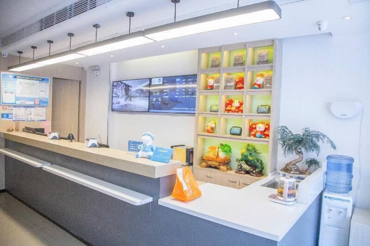 A reception desk with a digital screen, informational posters, and a shelf with plush toys.