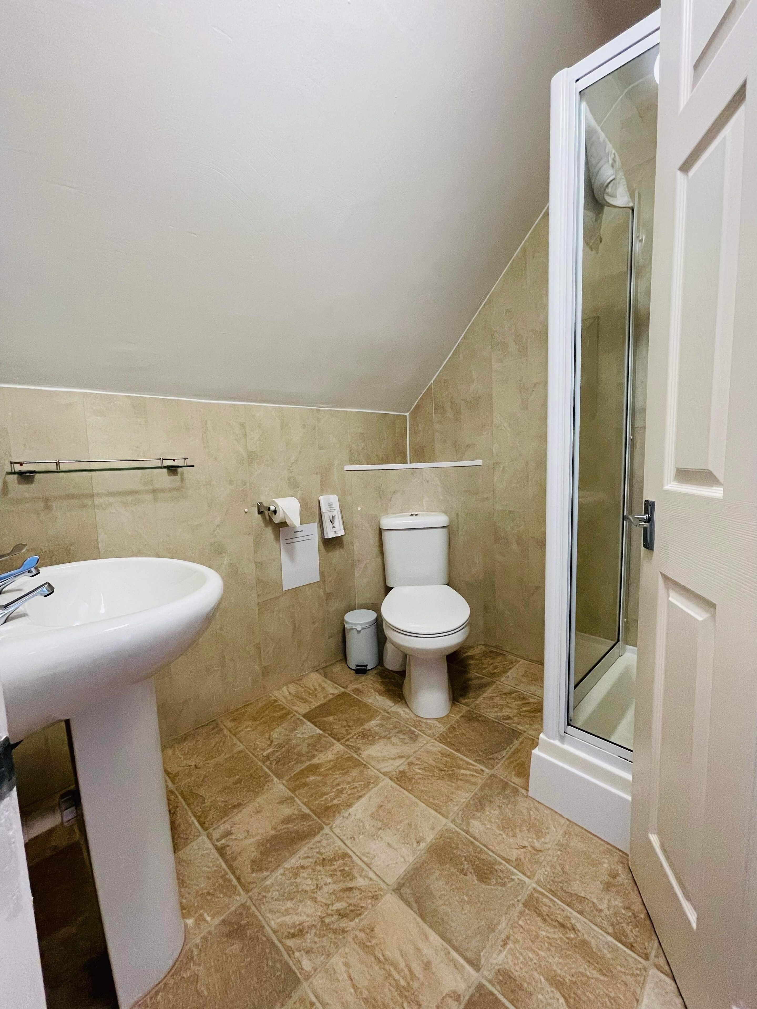 A bathroom with a sink, toilet, and shower.