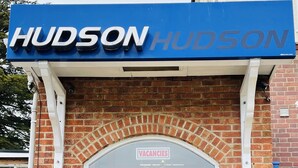 A hotel entrance with a blue sign reading "HUDSON HUDSON" and a "VACANCIES" sign above the door. - Hotel Hudson (Torquay)