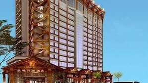 A multi-story hotel with a traditional architectural style, featuring a prominent entrance with a covered area and a series of windows on the facade. - Chenxi Fengqing Hotel (Zhaoqing)