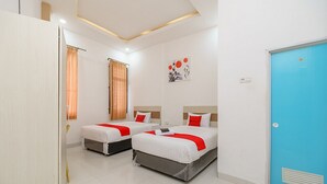 A hotel room with two beds, a blue door, and a painting on the wall. - RedDoorz near Palembang Trade Center (Palembang)
