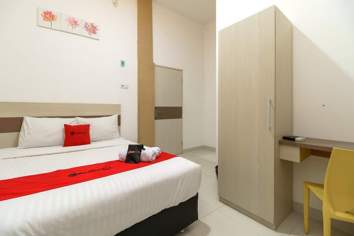 Ein Hotelzimmer mit Bett, Schreibtisch, Kleiderschrank und Stuhl.