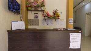 A reception desk with a calendar, a notice board, and floral arrangements. - RedDoorz near Palembang Trade Center (Palembang)