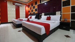 A hotel room with two beds, a large mirror, and a red and white color scheme. - RedDoorz Plus near DC Mall Batam (Batam)