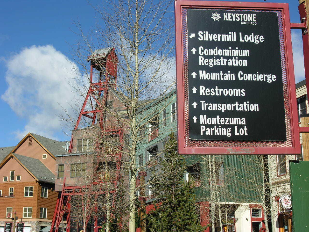 Un panneau indiquant les services disponibles, notamment le Silvermill Lodge, l’enregistrement pour les copropriétés, un service de conciergerie pour les activités de montagne, des toilettes, un service de transport et le parking de Montezuma.