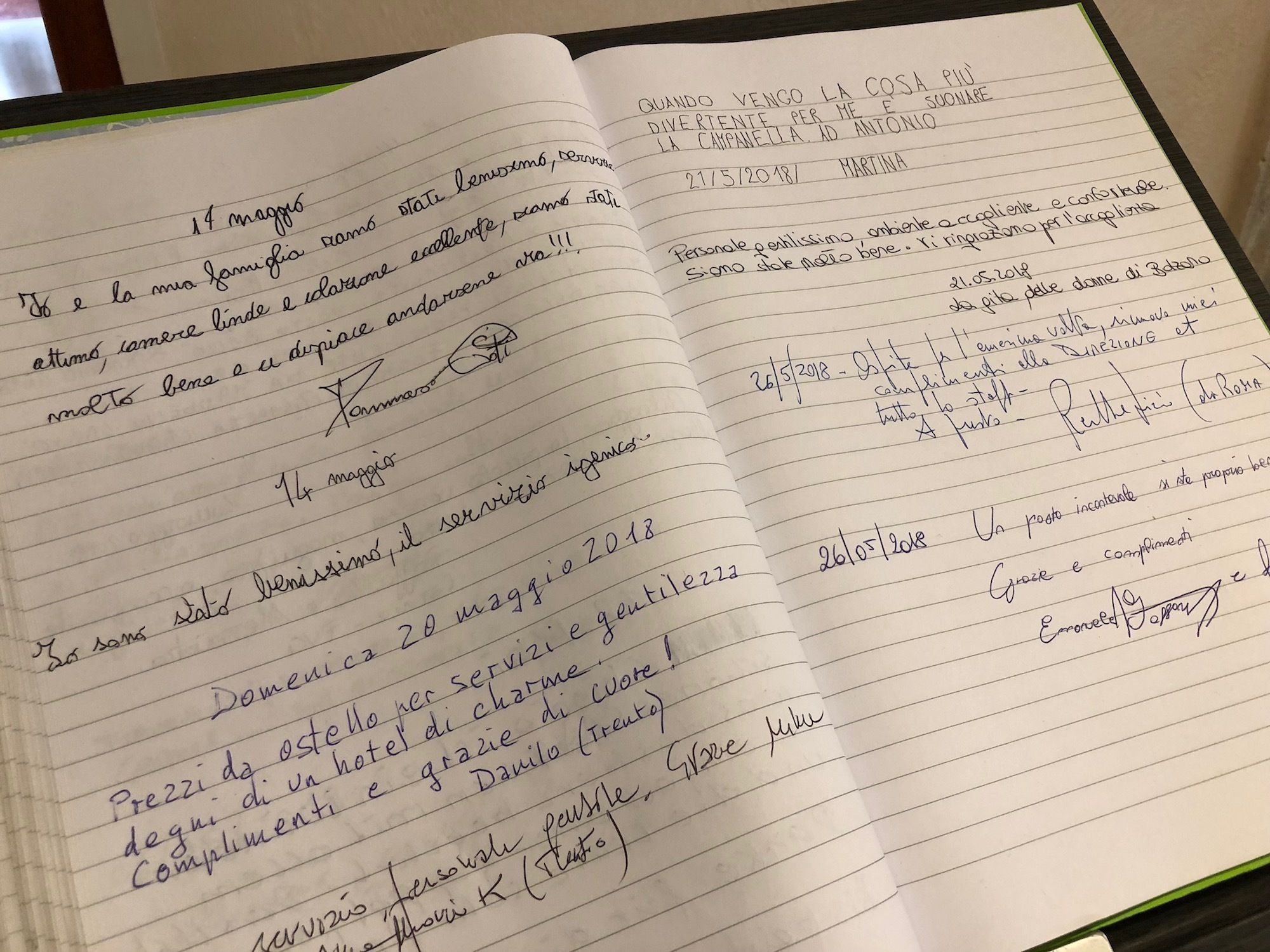 A notebook with handwritten notes in Italian, including dates and names, suggesting personal travel or event planning.