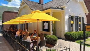 A restaurant with outdoor seating and yellow umbrellas. - Downtown Aspen Vacation Rentals (Aspen)