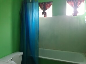 A bathroom with a bathtub, a toilet, and a shower curtain. - Victorious (Hopewell)