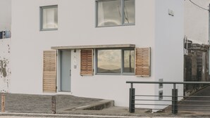 A modern two-story building with large windows, a flat roof, and a small front porch. - Ocean Views by Azores Villas (Ponta Delgada)