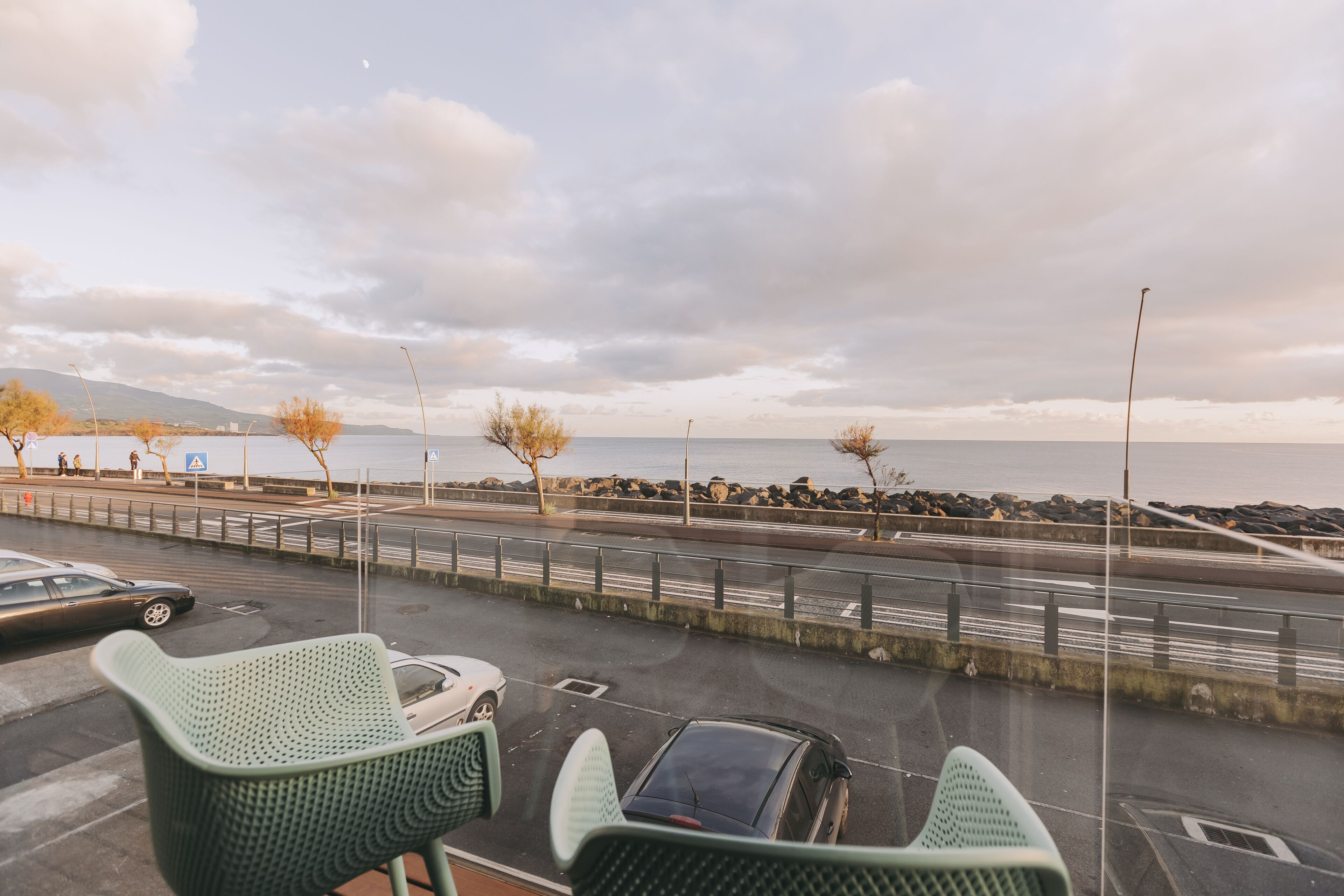 Een parkeerplaats met uitzicht op zee en bergen.