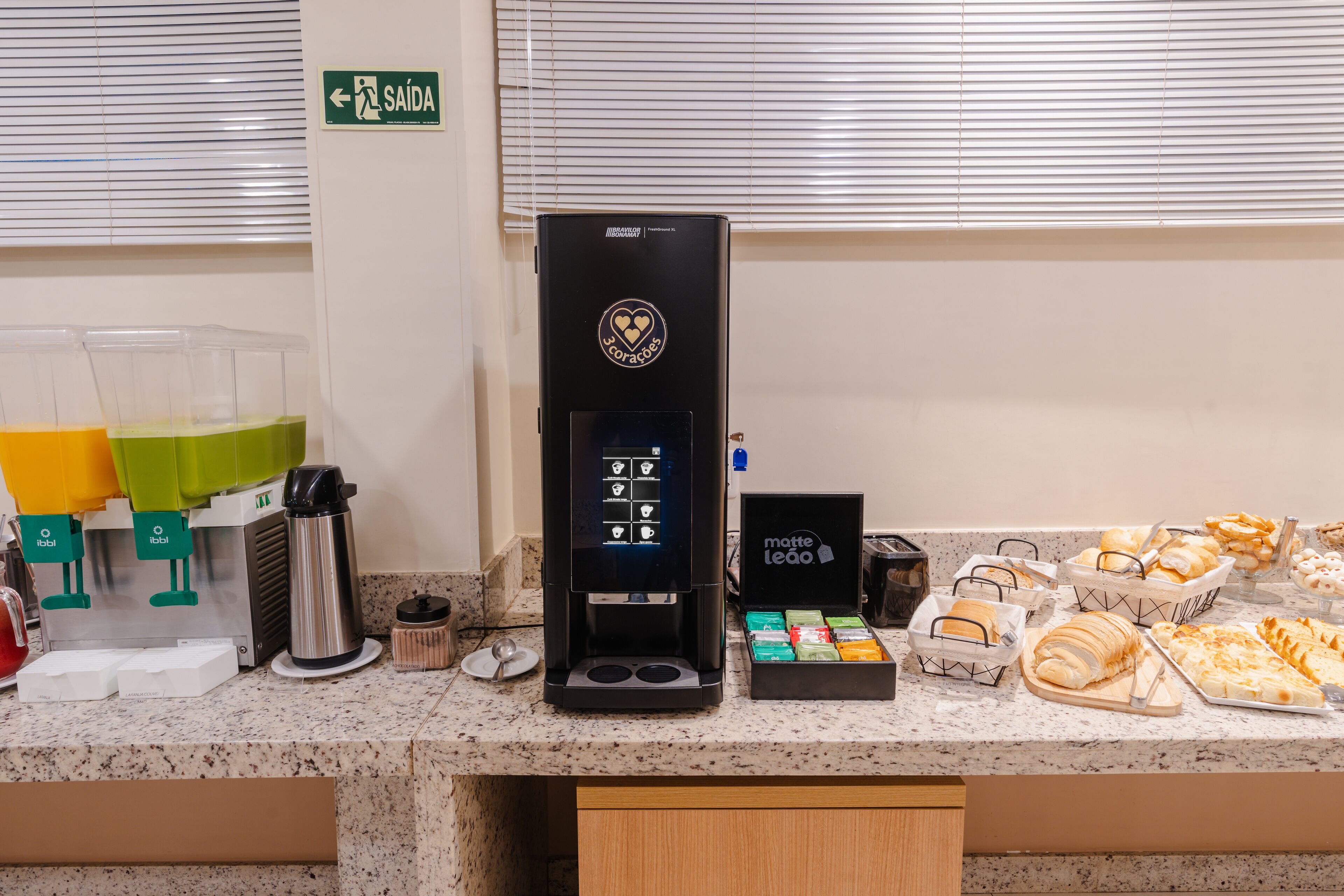 Un espace dédié au café, équipé d’une machine à café, de distributeurs de jus et proposant une variété de viennoiseries et de pains.