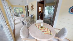 Un espace de détente intérieur, chaleureux, avec une table ronde, des fauteuils confortables et un chemin de table décoratif.