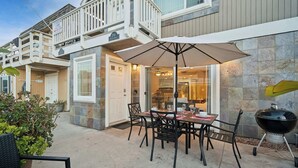A patio with a dining table, chairs, and a grill. - Waking up in your own 3BR beach home!-C8 (Newport Beach)