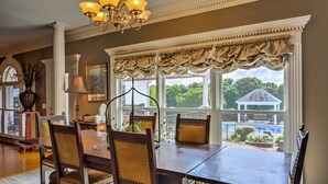 A dining room with a large table, chairs, and a chandelier.