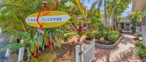 A pathway leading to a gated area with a sign reading "107 Island Getaway."