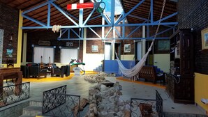 Un vestíbulo amplio con techo alto, una hamaca y un área de descanso con sofás y sillones.