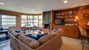 Una sala de estar acogedora con un sofá, una mesa de centro y una chimenea. Hay un comedor con una mesa y sillas.
