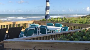 A wooden deck with outdoor seating and a view of the ocean. - Awesome direct ocean beach house! (cocoa beach)