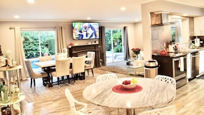 Een moderne woonkamer met een open haard, eethoek en keuken.