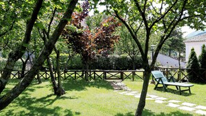 Un jardín con cerca de madera, un banco y un camino.