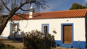A white building with blue trim and a red-tiled roof.