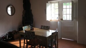A dining area with a wooden table and chairs, a fireplace, a mirror, and a door with a window.