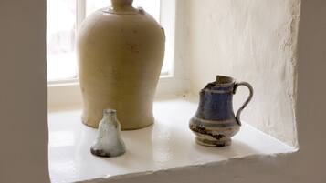 Three ceramic vases on a white ledge by a window.
