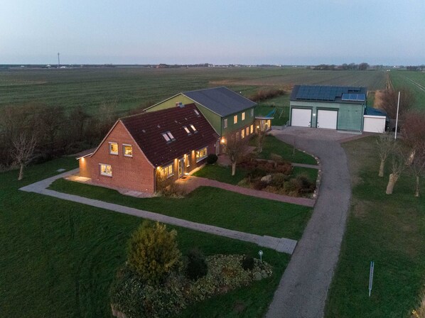 A large house with a paved driveway and a well-maintained lawn.