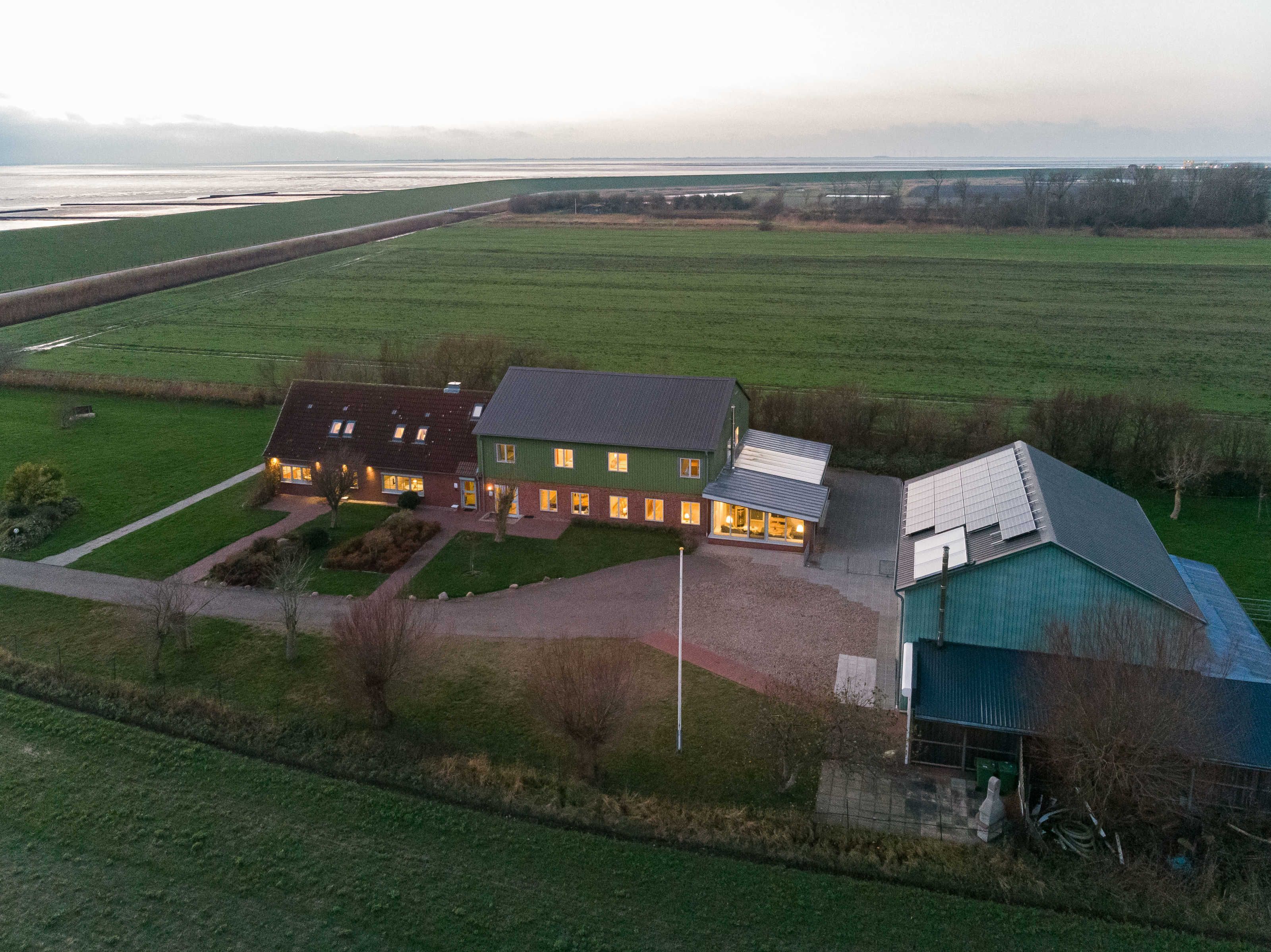 Ein großes Haus mit mehreren Zimmern, einer Garage und einem grünen Feld im Hintergrund.