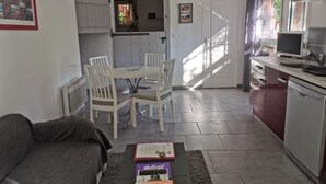 Un espace de vie compact comprenant un coin repas, une cuisine et un coin salon.