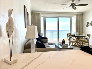 Relax in a spacious room with a sofa, armchairs, and dining table, offering a view of the ocean.