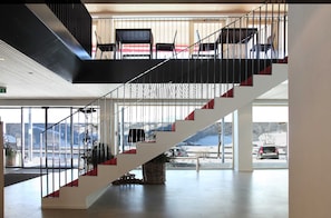 A modern interior with a staircase, large windows, and a view of a snowy landscape.