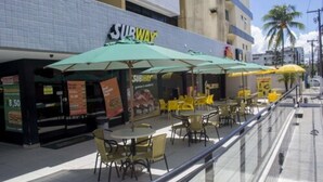 Un restaurant Subway amb terrassa i ombrelles.
