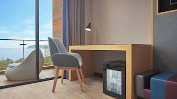 A modern room with a desk, chair, and seating area.