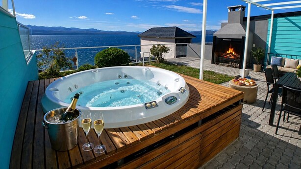 A hot tub with champagne, a fireplace, and a view of the sea. - Apartments Bariloche - Luxury Lake Views (San Carlos de Bariloche)