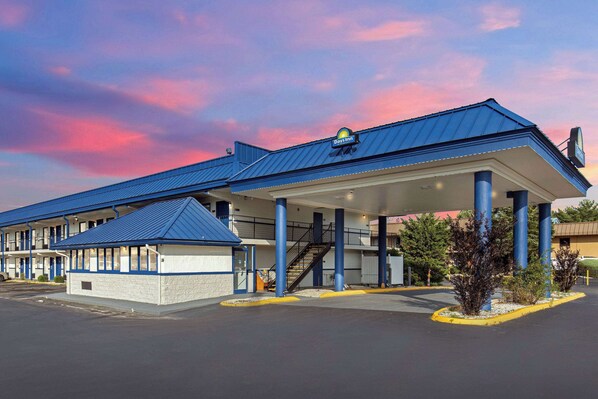 A Days Inn with a blue roof, a covered parking area, and a staircase leading to the entrance. - Days Inn by Wyndham Knoxville North (Knoxville)