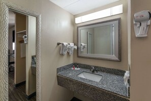 A bathroom with a granite sink, a mirror, a towel rack, and a hair dryer. - Days Inn by Wyndham Knoxville North (Knoxville)