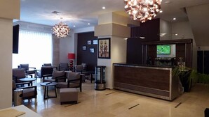 Un vestíbul modern amb taulell de recepció, zona de seients i il·luminació decorativa.