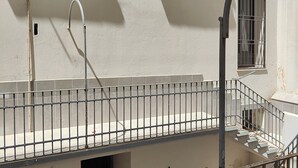 Una escalera con barandillas de metal que conduce a un rellano con piso de baldosas.